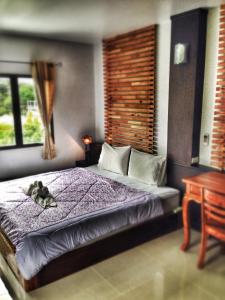 a bedroom with a bed with a dog laying on it at Lanta Manta Apartment in Ko Lanta