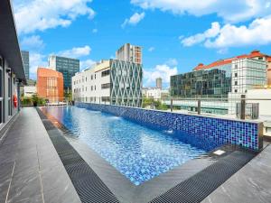 a swimming pool on the roof of a building with buildings at ibis budget Singapore Clarke Quay in Singapore
