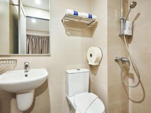 a bathroom with a toilet, sink, and shower at Ibis Budget Singapore Clarke Quay in Singapore