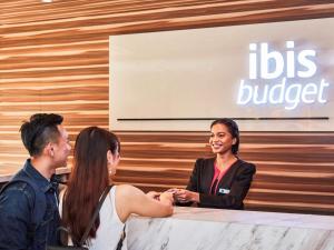 een groep van drie personen die aan een tafel zitten bij ibis budget Singapore Crystal in Singapore