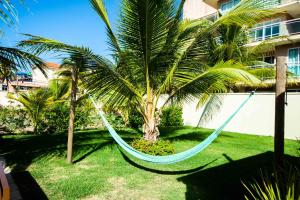 a hammock hanging between two palm trees in a yard at BEACH PARK PALM - COBERTURA Luxo in Aquiraz