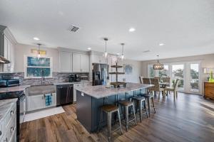 a kitchen with white cabinets and a large island with bar stools at Breathtaking Waterfront Crystal Beach Getaway! in Palm Harbor