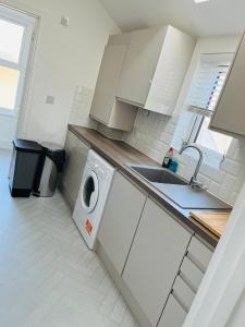 a kitchen with a washing machine and a sink at Castle view Rochester in Rochester