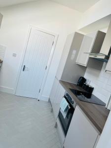 a white kitchen with a white door and a counter at Castle view Rochester in Rochester