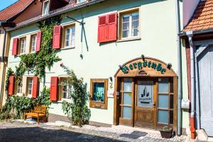 un bâtiment avec volets rouges dans une rue dans l'établissement Pension Bergstube, à Bad Langensalza