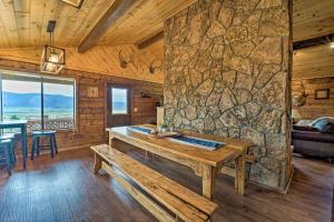a room with a wooden table and a stone wall at Sprawling Mountain-View Cabin 5 Mi to Mesa Verde in Mancos