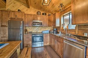 a kitchen with wooden cabinets and stainless steel appliances at Sprawling Mountain-View Cabin 5 Mi to Mesa Verde in Mancos