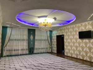 a large room with a chandelier and a ceiling at Green house in Nukus