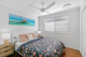 a bedroom with a bed and a window at Ivy Street 7 Dicky Beach in Caloundra