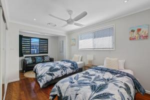 a bedroom with two beds and a ceiling fan at Ivy Street 7 Dicky Beach in Caloundra +27 photos