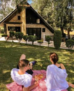 a group of people sitting on a picnic blanket at Vikendice Stara Pruga in Gornji Milanovac +67 photos