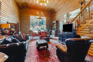 a living room with leather furniture and a flat screen tv at Antler River Lodge in Guerneville