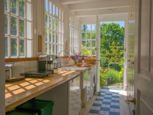 eine Küche mit Blick auf den Garten durch die Fenster in der Unterkunft Manoir Bellevue in Duravel