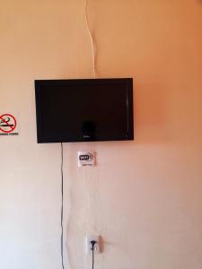 a flat screen tv hanging on a wall at Hotel 3 irmaos in Três Marias