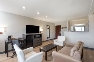 a living room with a couch and a desk and a tv at Days Inn by Wyndham Somerset PA I-70 I-76 in Somerset