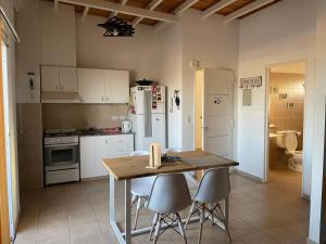 a kitchen with a table and chairs and a refrigerator at Depto Maipú in Maipú