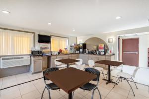 una cucina con due tavoli, sedie e bancone di Days Inn by Wyndham Somerset PA I-70 I-76 a Somerset