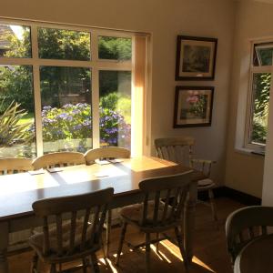 d'une salle à manger avec une table, des chaises et une fenêtre. dans l'établissement Lurgan West Lodge, à Randalstown