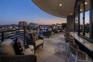 a rooftop bar with chairs and a view of the city at Sentral Old Town in Scottsdale