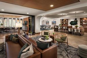 a living room with a couch and chairs and a bar at Sentral Old Town in Scottsdale