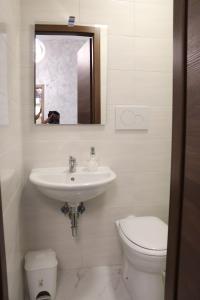 W łazience znajduje się umywalka, toaleta i lustro. w obiekcie Relaxon Guest House w Rzymie