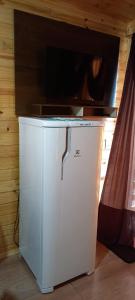 Un mueble blanco con un televisor encima. en Cabanas Campinho, en Mundo Novo