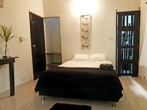 a bedroom with a large bed with a black blanket at Gui=Neo in Minca