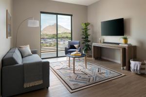 uma sala de estar com um sofá, uma mesa e uma televisão em Sentral Old Town em Scottsdale