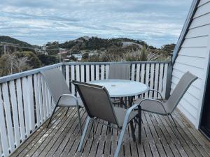 a table and two chairs on a deck with a table at Barefoot Bungalow in Bicheno