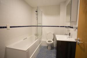 a bathroom with a tub and a toilet and a sink at Diamond Apartment in Belfast +14 photos