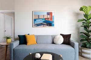 a living room with a blue couch with yellow pillows at Sentral Old Town in Scottsdale