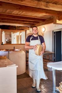 a man standing in a kitchen holding a pot at Nestalp Malga Campo in Peio