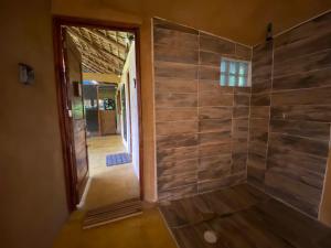 a walk in shower with a wooden wall at Cabaña DREAM HOUSE in San Agustinillo