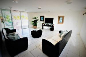 a living room with black chairs and a piano at BEACH PARK PALM - COBERTURA Luxo in Aquiraz