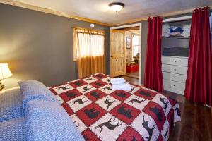 a bedroom with a bed with a quilt on it at Steps from Downtown Pigeon Forge Parkway + Private Hottub and firepit - Wifi - Firefly Bungalows in Pigeon Forge