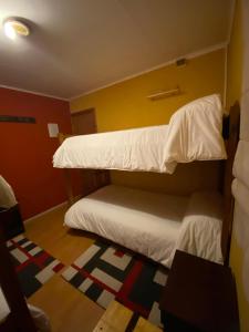 two bunk beds in a room with a rug at Konkashken Lodge in Torres del Paine