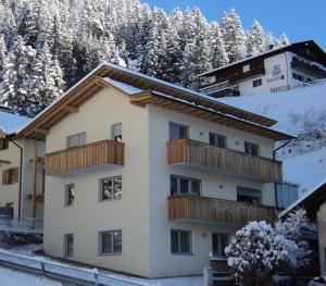 a building with a balcony in the snow at Apartment Welscher in Nova Levante