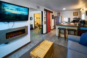 a living room with a large flat screen tv on a wall at Steps from Downtown Pigeon Forge Parkway + Private Hottub and firepit - Wifi - Firefly Bungalows in Pigeon Forge