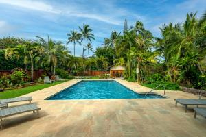 uma piscina com dois bancos e palmeiras em Hanalei Colony Resort J3 em Hanalei