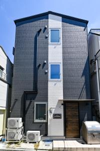 a black brick building with two windows and a door at Hotel AZUMA SEE in Tokyo