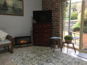 a living room with a fireplace and a television at Rocky Rest in Orange