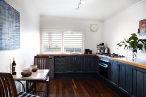 a kitchen with black cabinets and a table with a tableablish at Chestnut Daylesford in Daylesford