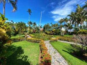 a garden in a resort with palm trees and flowers at Villa 20 in Las Terrenas