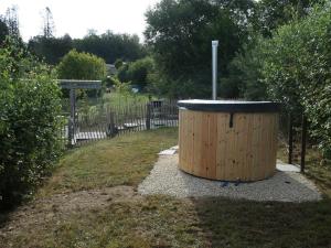 a wooden barrel sitting in the middle of a yard at Villa with hottub in calm area in Bièvre