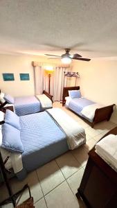 a bedroom with three beds and a ceiling fan at lovely 2BED 2BA vacation rental near the Beach in Pompano Beach