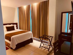 a bedroom with a bed and a chair and a window at San Francisco Hotel Boutique in Huajuapan de León