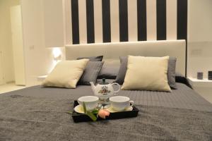 ローマにあるInterno 7 Luxury Rooms B&Bのベッド1台(トレイ、カップ、お茶セット付)