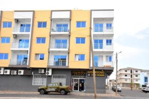 a yellow building with a car parked in front of it at Lovely - Luxury 3 Bedrooms 500m from the Beach. in Santa Maria