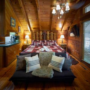ein Schlafzimmer mit einem Bett in einer Holzhütte in der Unterkunft Gatlinburg Area Hottub Cabin - Ladyslipper in Sevierville