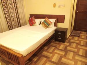 a bedroom with a bed with pillows on it at Swasthi Griha in Aranmūla